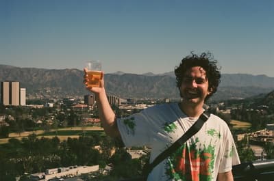 a man holding up a glass of beer