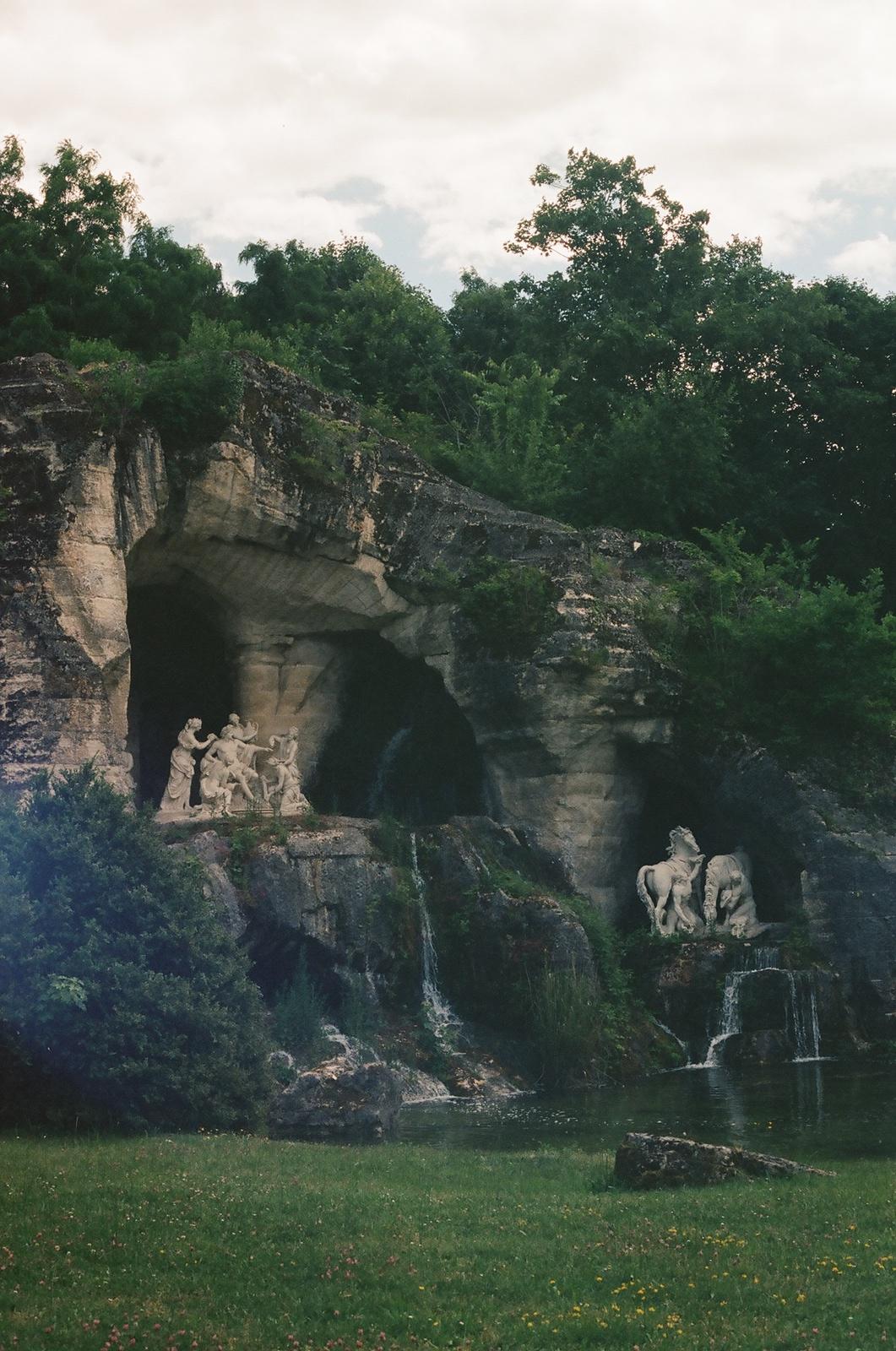 an aerial view of a grassy area with a rock formation