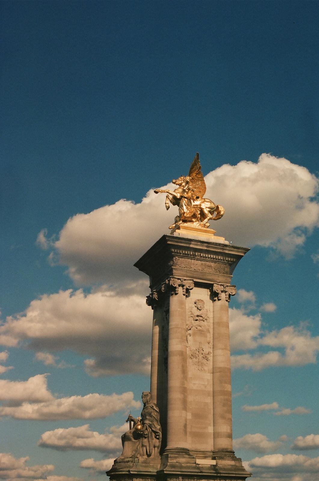 a tall tower with a statue on top of it