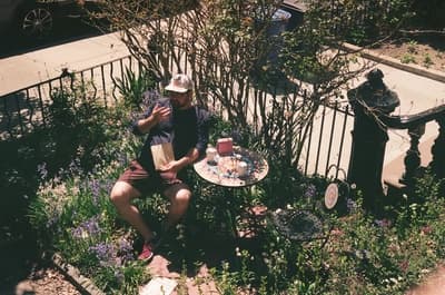 a man sitting on a bench in a garden