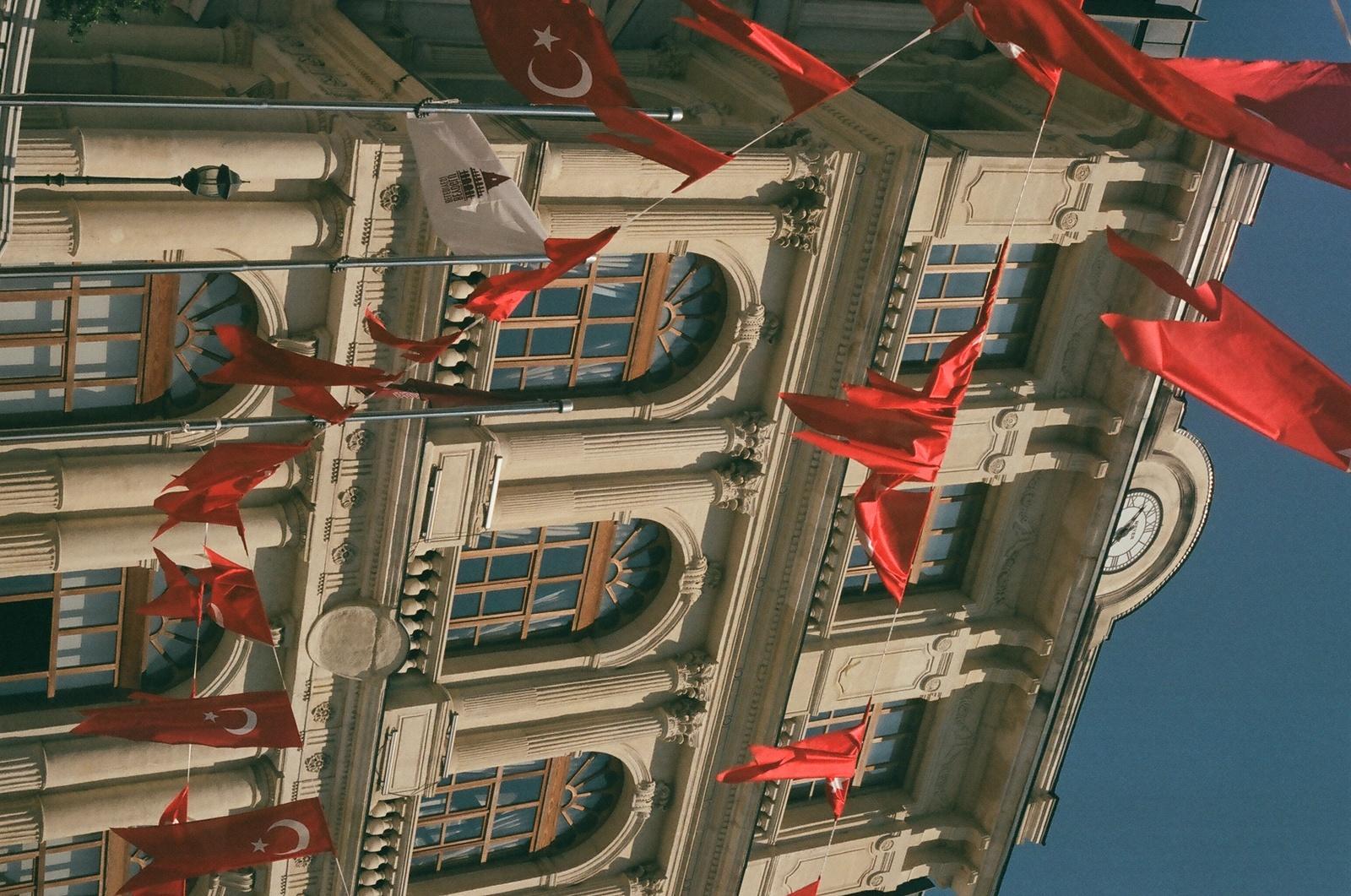 a building with red flags flying from it's windows