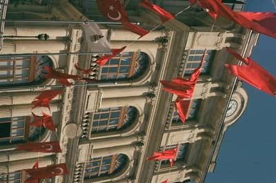 a building with red flags flying from it's windows