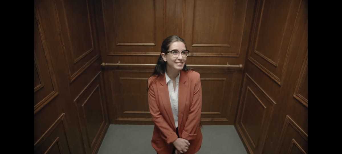 a woman standing in a room with wood paneling