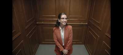 a woman standing in a room with wood paneling