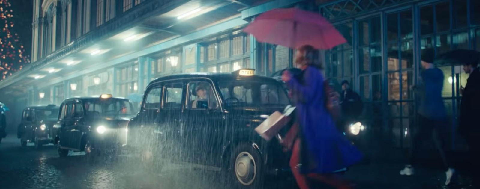 a woman in a blue dress is holding an umbrella