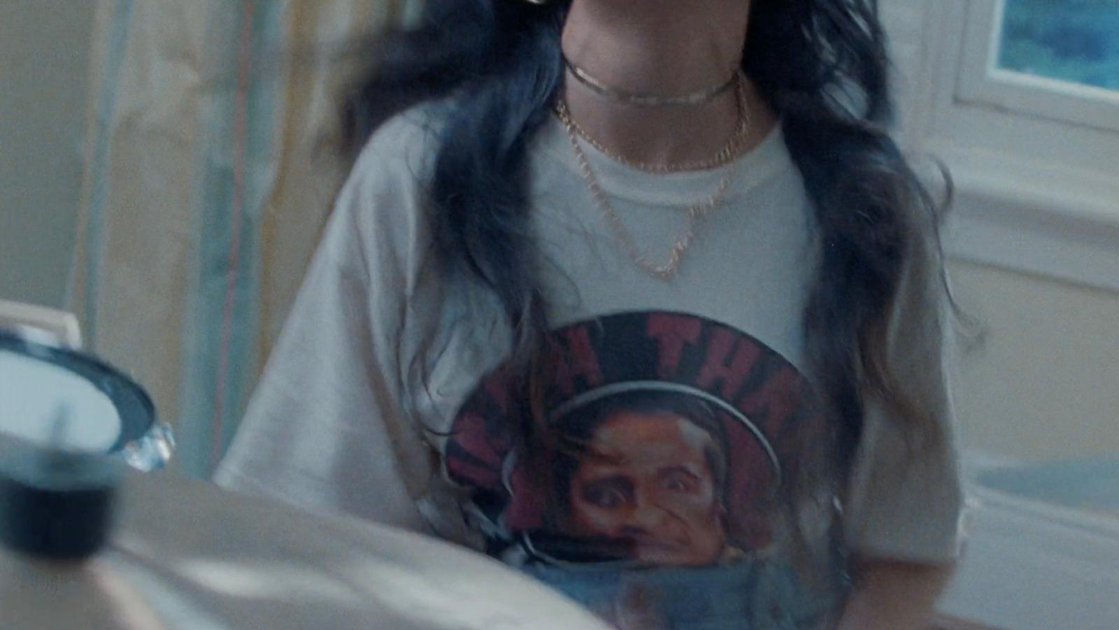 a woman with long black hair wearing a t - shirt with a picture of a