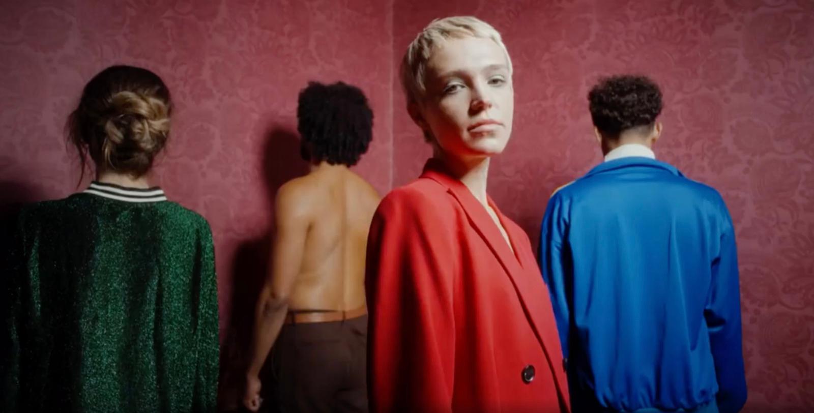 a group of people standing in front of a red wall
