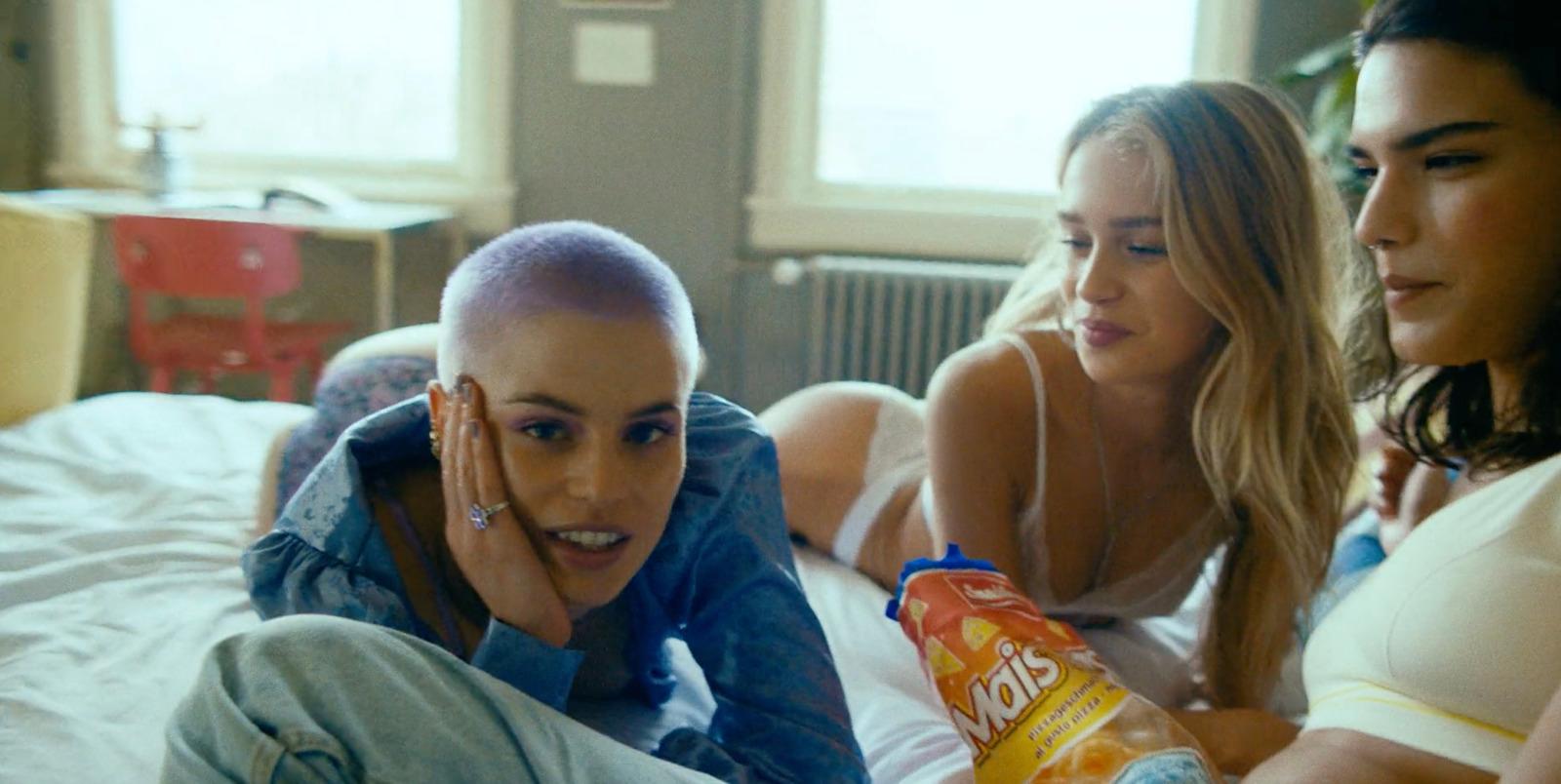 a group of women sitting on a bed next to each other