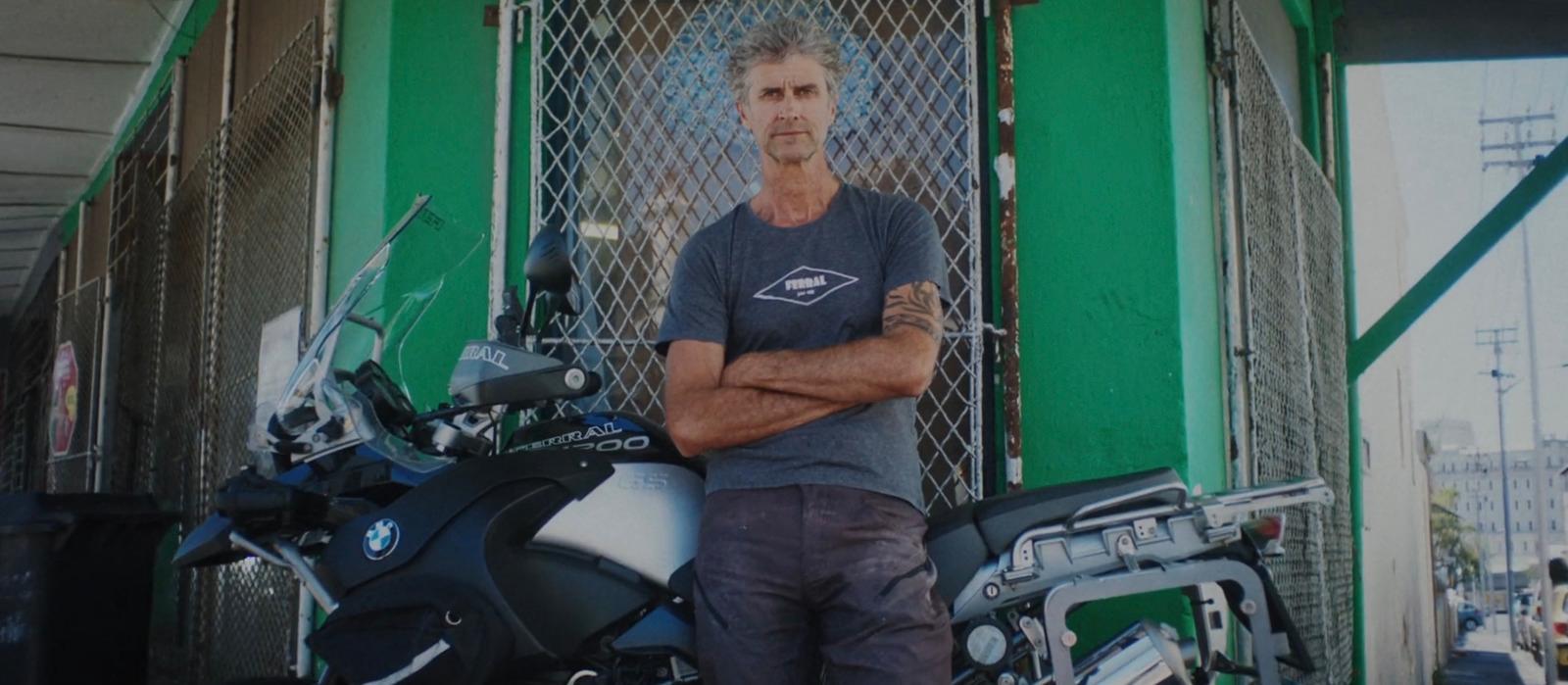 a man standing next to a parked motorcycle