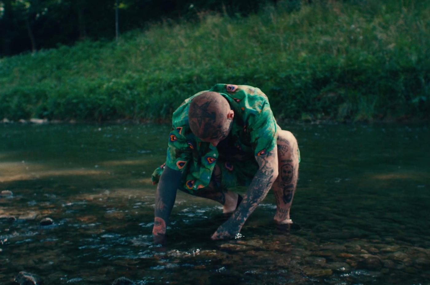 a man in a green shirt standing in a river