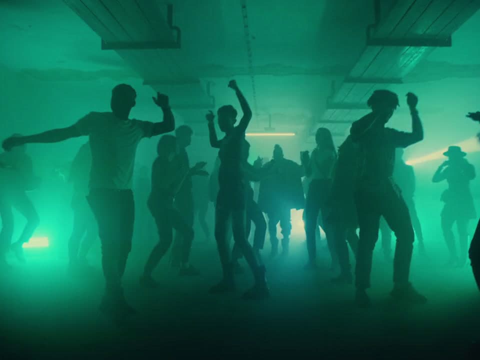 a group of people dancing in a dark room
