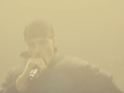 a man in a black jacket holding a microphone