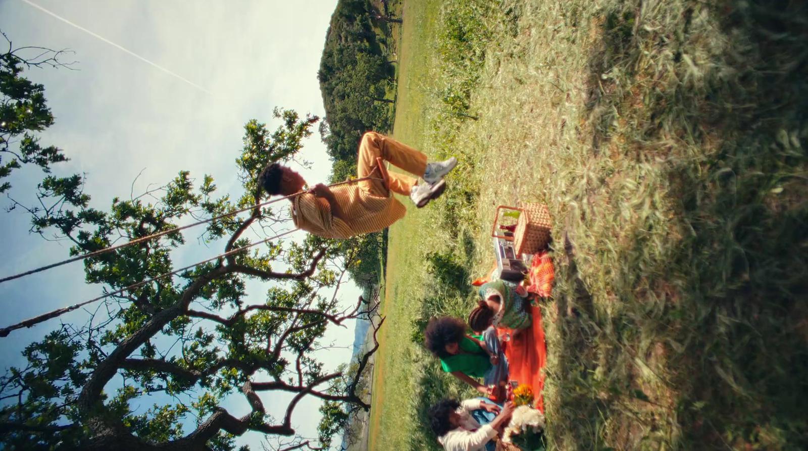 a group of people standing around a lush green field