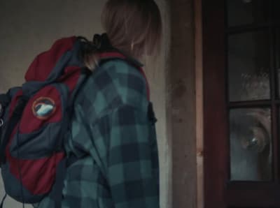 a person with a backpack standing in front of a door