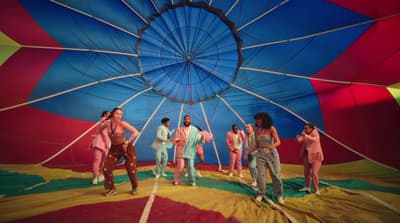 a group of people standing inside of a colorful hot air balloon