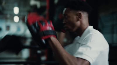 a man wearing boxing gloves in a gym