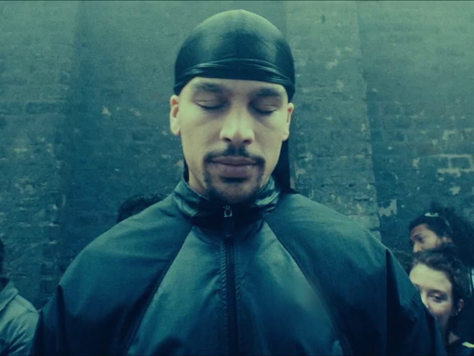 a man wearing a black hat and a black jacket