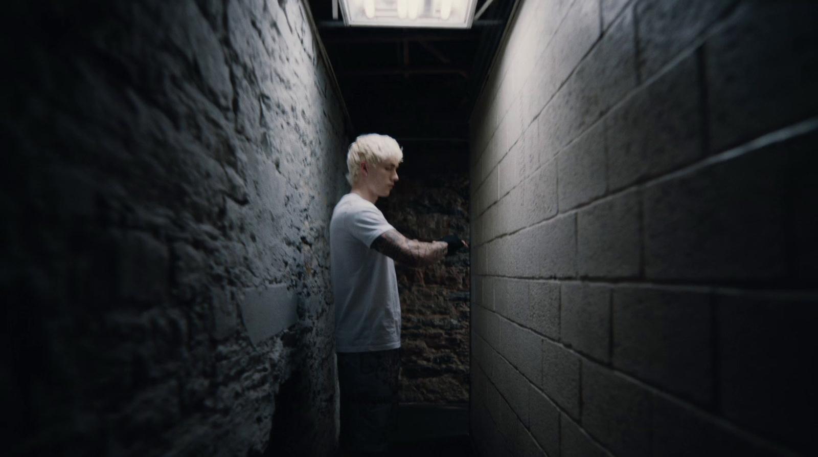 a man standing in a narrow alley between two walls