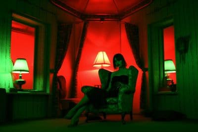 a woman sitting in a chair in front of a red light