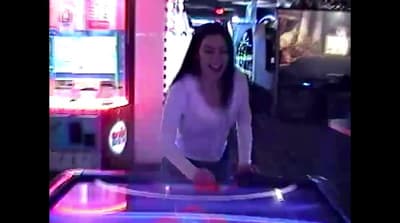 a woman in a white shirt is playing a video game