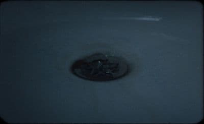 a sink with a drain in it in a bathroom