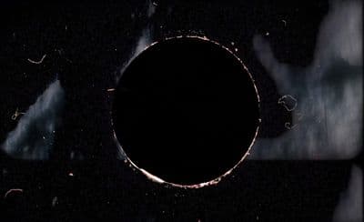 a black hole in the middle of a dark sky