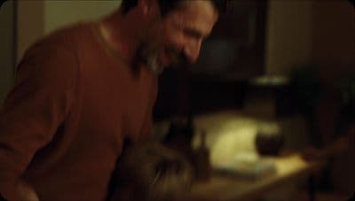 a man in a brown shirt is smiling