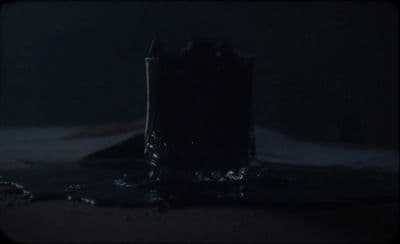 a pair of boots sitting on top of a bed in the dark