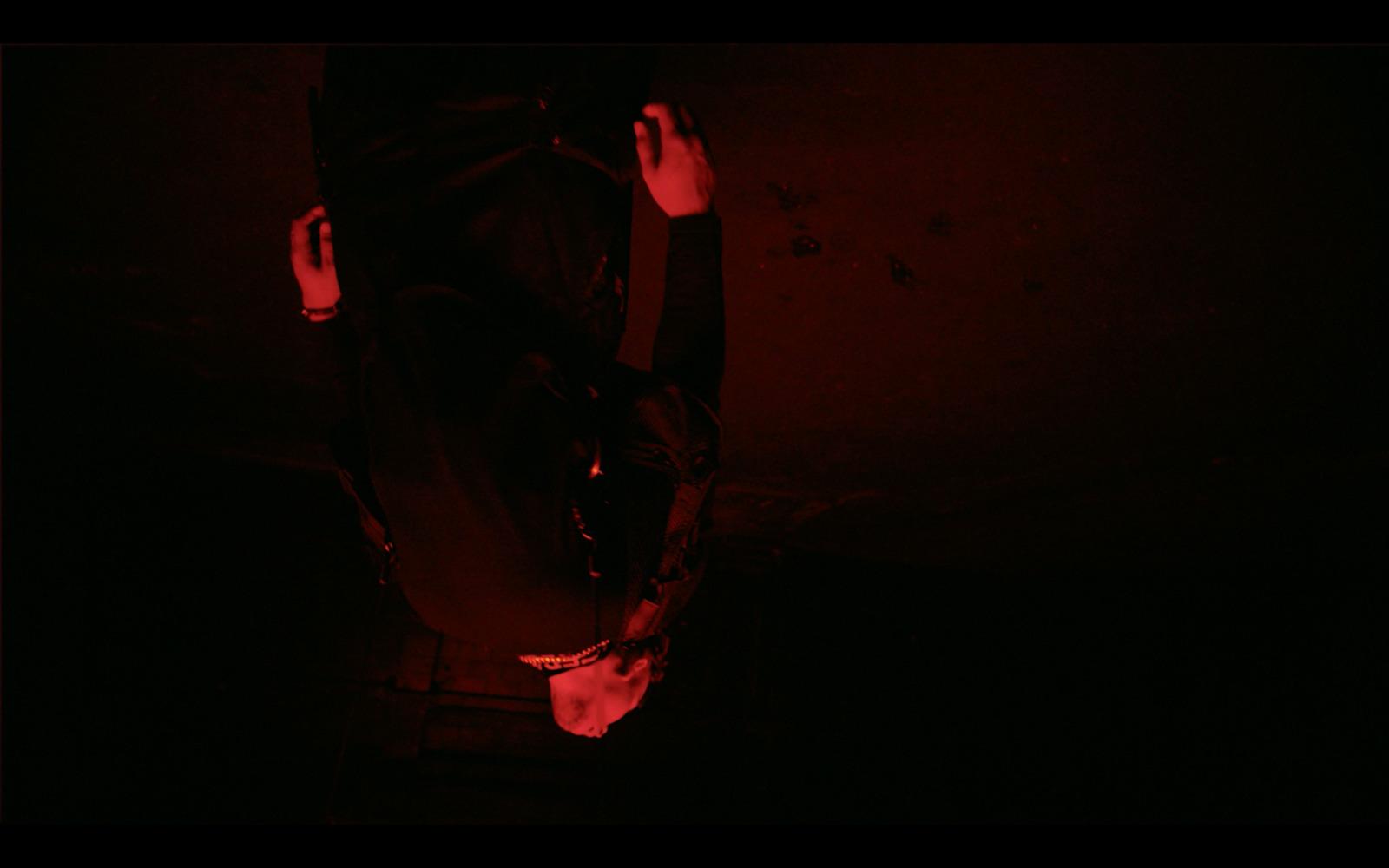 a person standing in the dark with their hands in the air