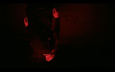 a person standing in the dark with their hands in the air