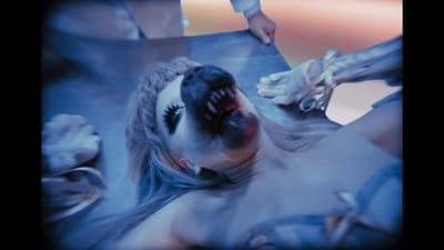 a woman with makeup on her face laying on the ground
