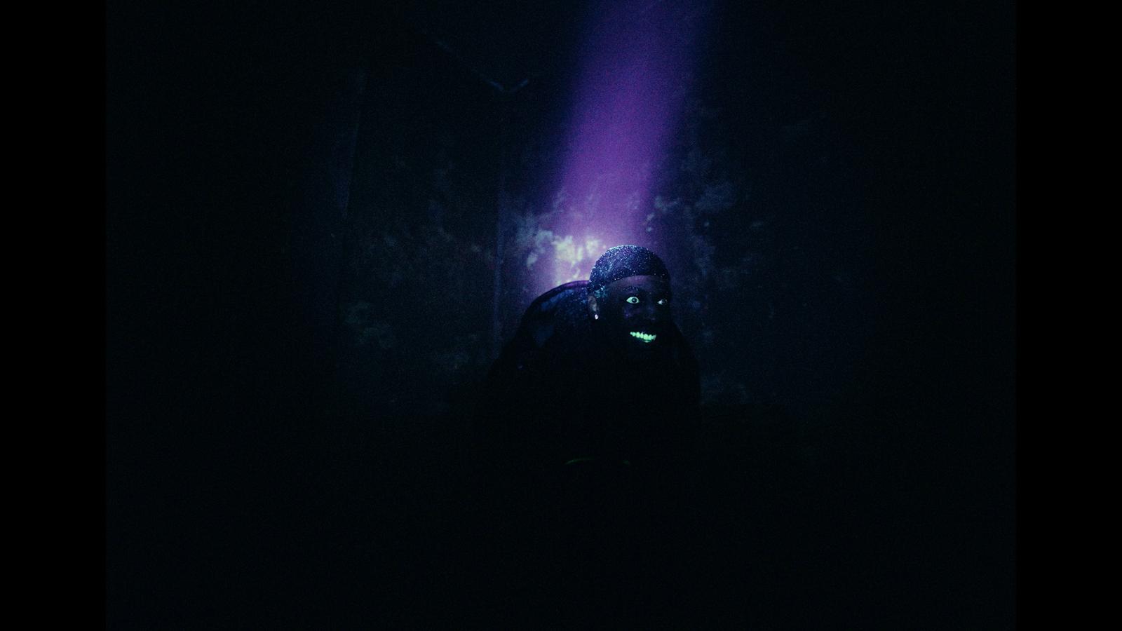 a person standing in the dark with a flashlight
