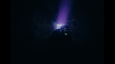 a person standing in the dark with a flashlight