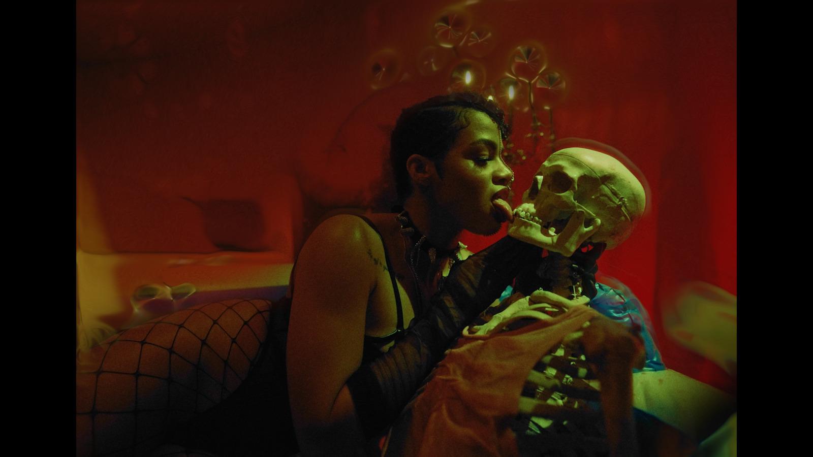 a woman sitting next to a skeleton in a room