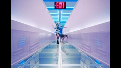 two people are walking down a long hallway