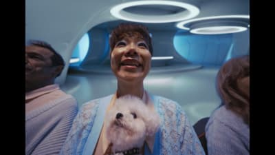 a woman holding a small white dog in her arms