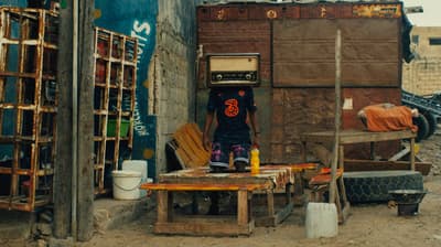 a man standing in the doorway of a shack
