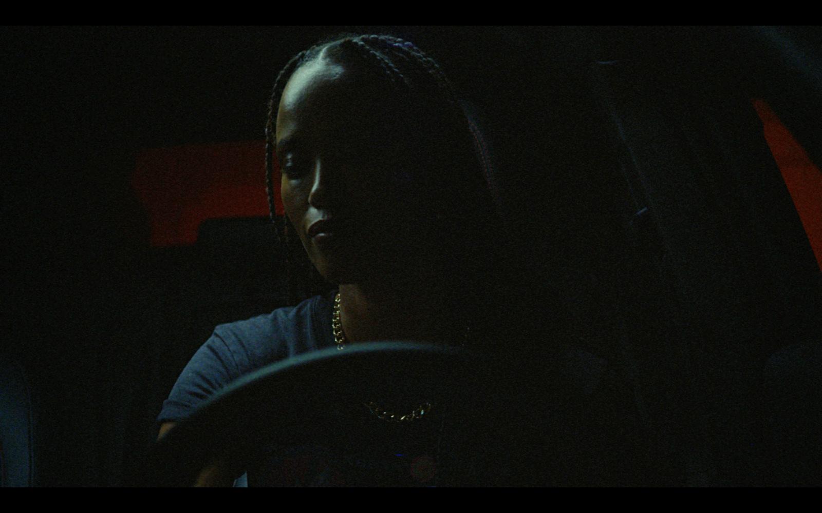 a woman driving a car in the dark