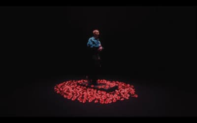 a man standing in the middle of a circle of hearts