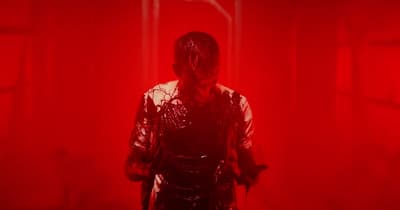 a person in a red light with a mask on