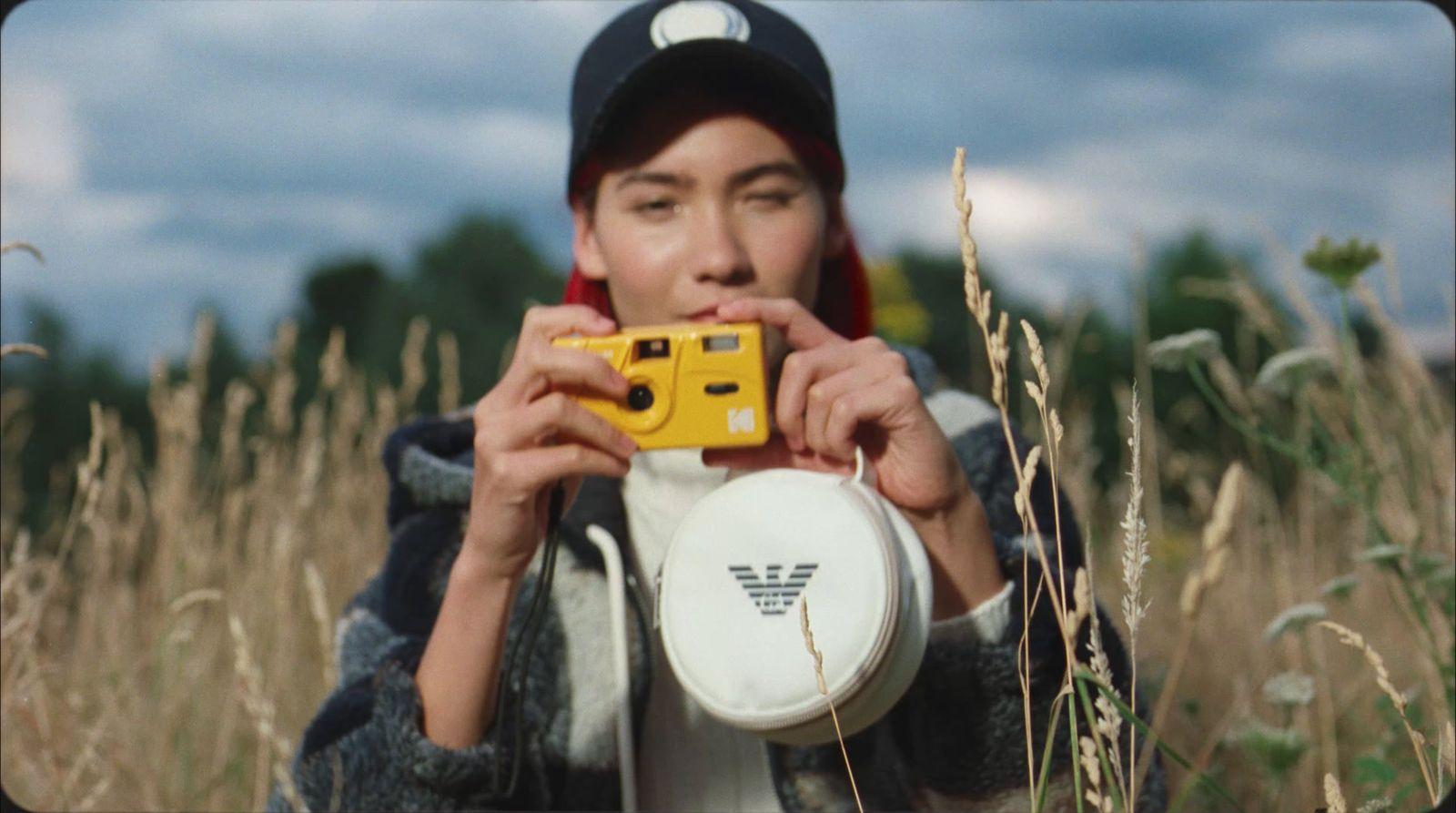 a person holding a camera and a frisbee