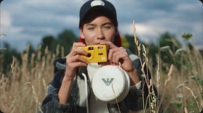 a person holding a camera and a frisbee