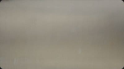 a close up of a metal surface with a black border