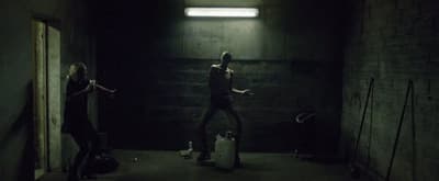 a man and a woman standing in a dark hallway