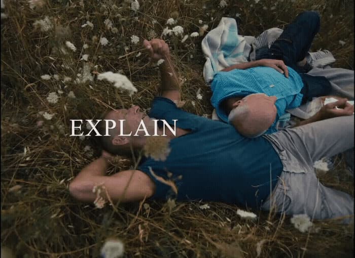 a man laying on top of a grass covered field