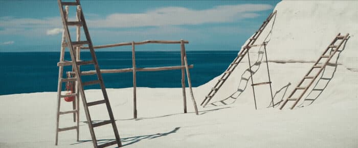 a ladder leaning up against a wall next to the ocean