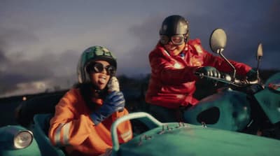 a man and a woman riding on the back of a motorcycle