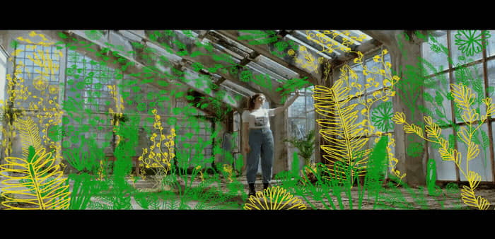 a woman standing inside of a greenhouse filled with plants