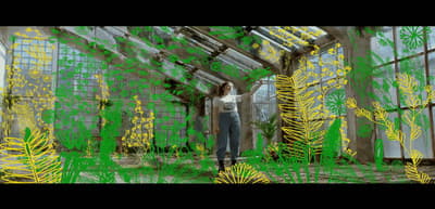 a woman standing inside of a greenhouse filled with plants