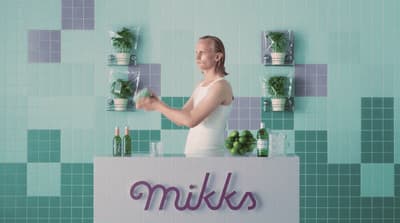 a woman standing in front of a display of plants